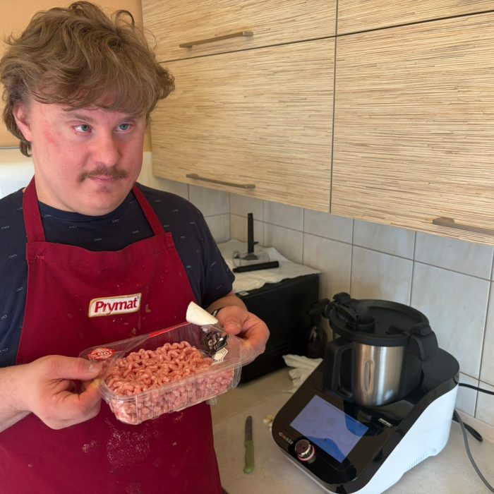 Mężczyzna obsługuje piłę włosową podczas zajęć stolarskich w pracowni.