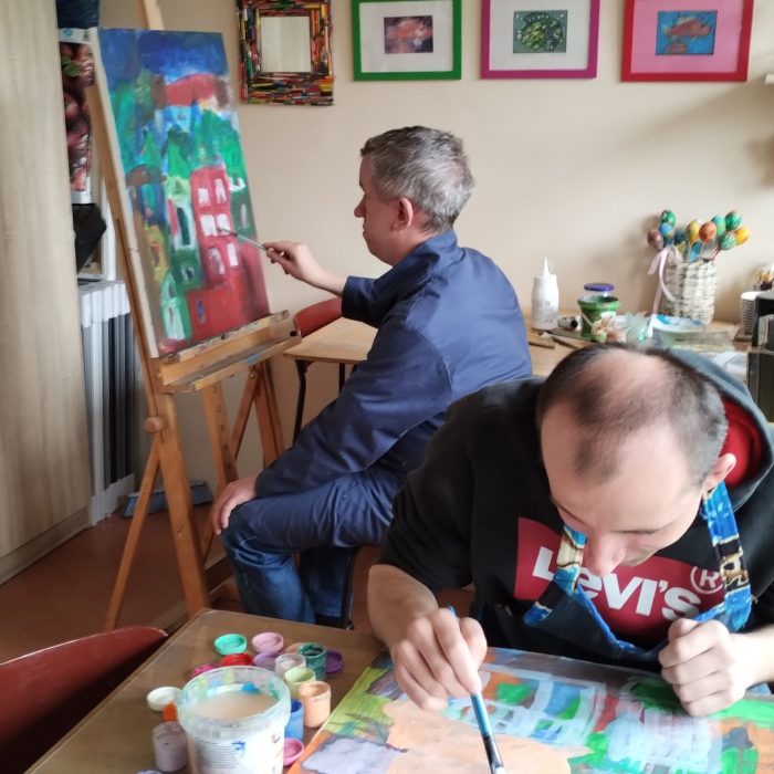 Uczestnik przygotowuje ciasto lub farsz podczas wspólnych zajęć kulinarnych.