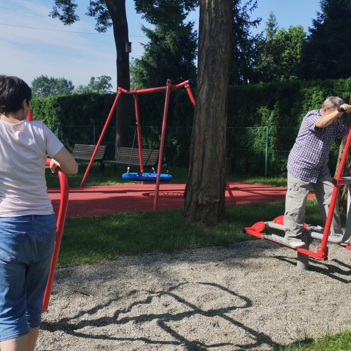 Uczestnik maluje kolorowy obraz na płótnie podczas zajęć plastycznych w pracowni.
