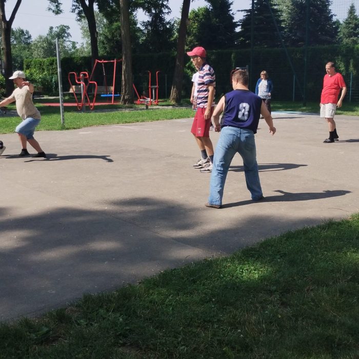 Uczestnicy korzystają z urządzeń siłowni plenerowej podczas aktywności na świeżym powietrzu.