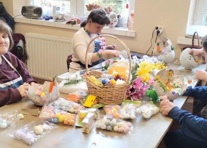 Uczestniczka zajęć rękodzielniczych czyści i poleruje kolorowe pisanki przygotowane na Wielkanoc.