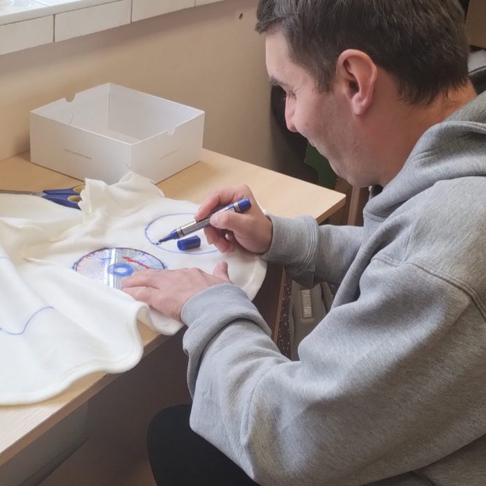 Dwie uczestniczki wykonują papierowe dekoracje podczas wspólnych zajęć plastycznych.