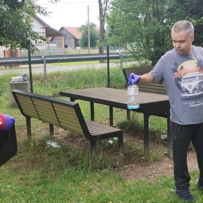 Mężczyzna w fartuchu kuchennym przygotowuje składniki do gotowania przy robocie kuchennym.